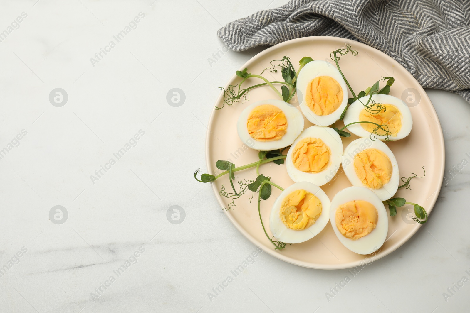 Boiled eggs, microgreens and oil on white marble table, top view. Space for text Photo of Boiled eggs, microgreens and oil on white marble table, top view. Space for text