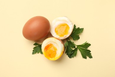 Photo of Soft boiled eggs and parsley on beige background, flat lay