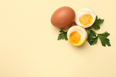Photo of Soft boiled eggs and parsley on beige background, flat lay. Space for text