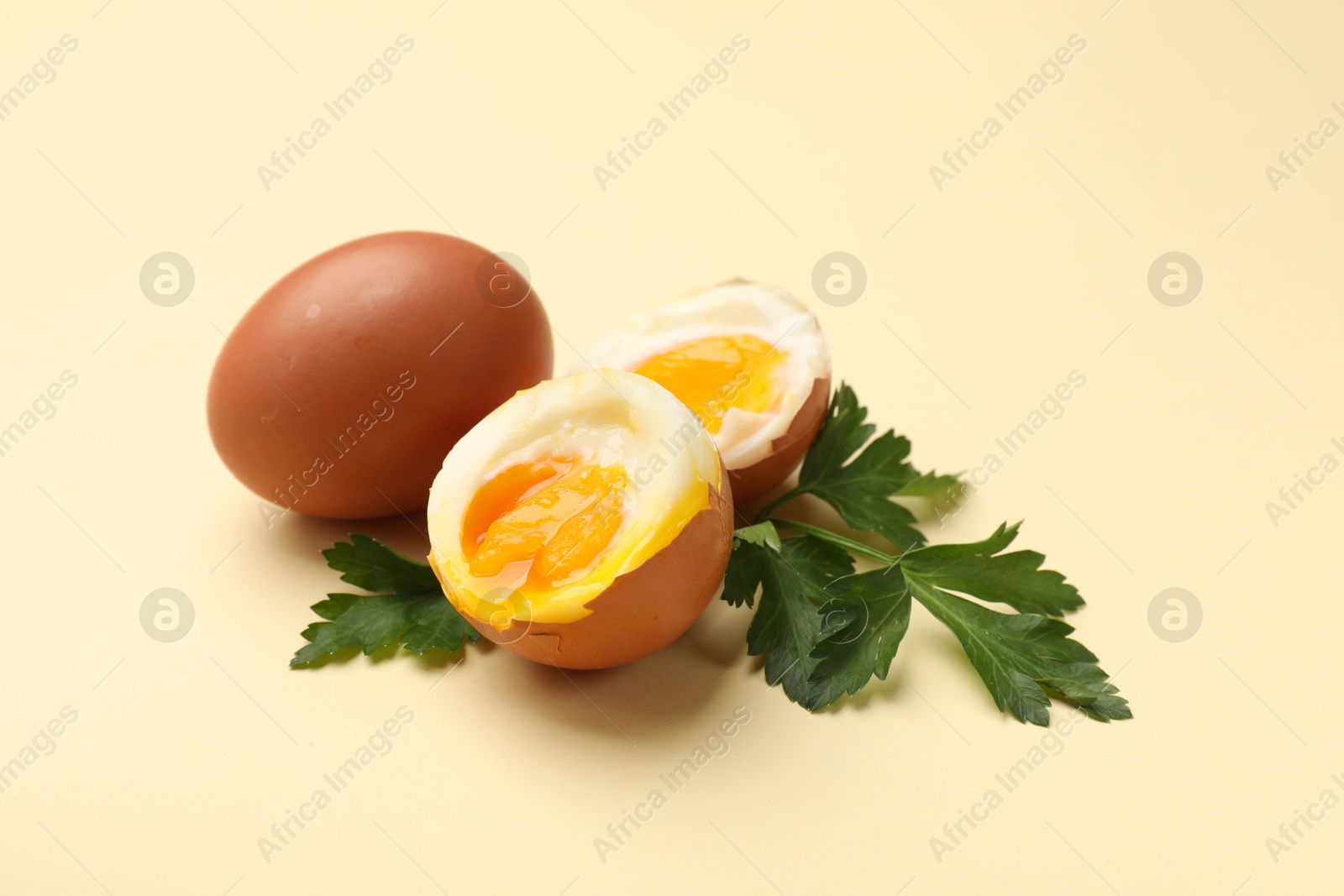 Soft boiled eggs and parsley on beige background, closeup Photo of Soft boiled eggs and parsley on beige background, closeup