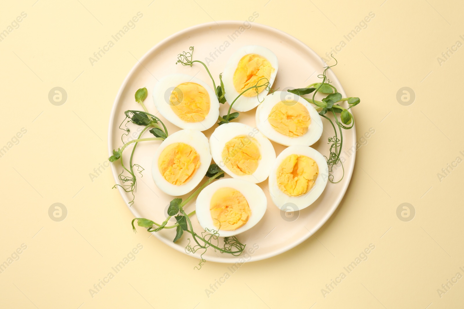Boiled eggs and microgreens on beige background, top view Photo of Boiled eggs and microgreens on beige background, top view