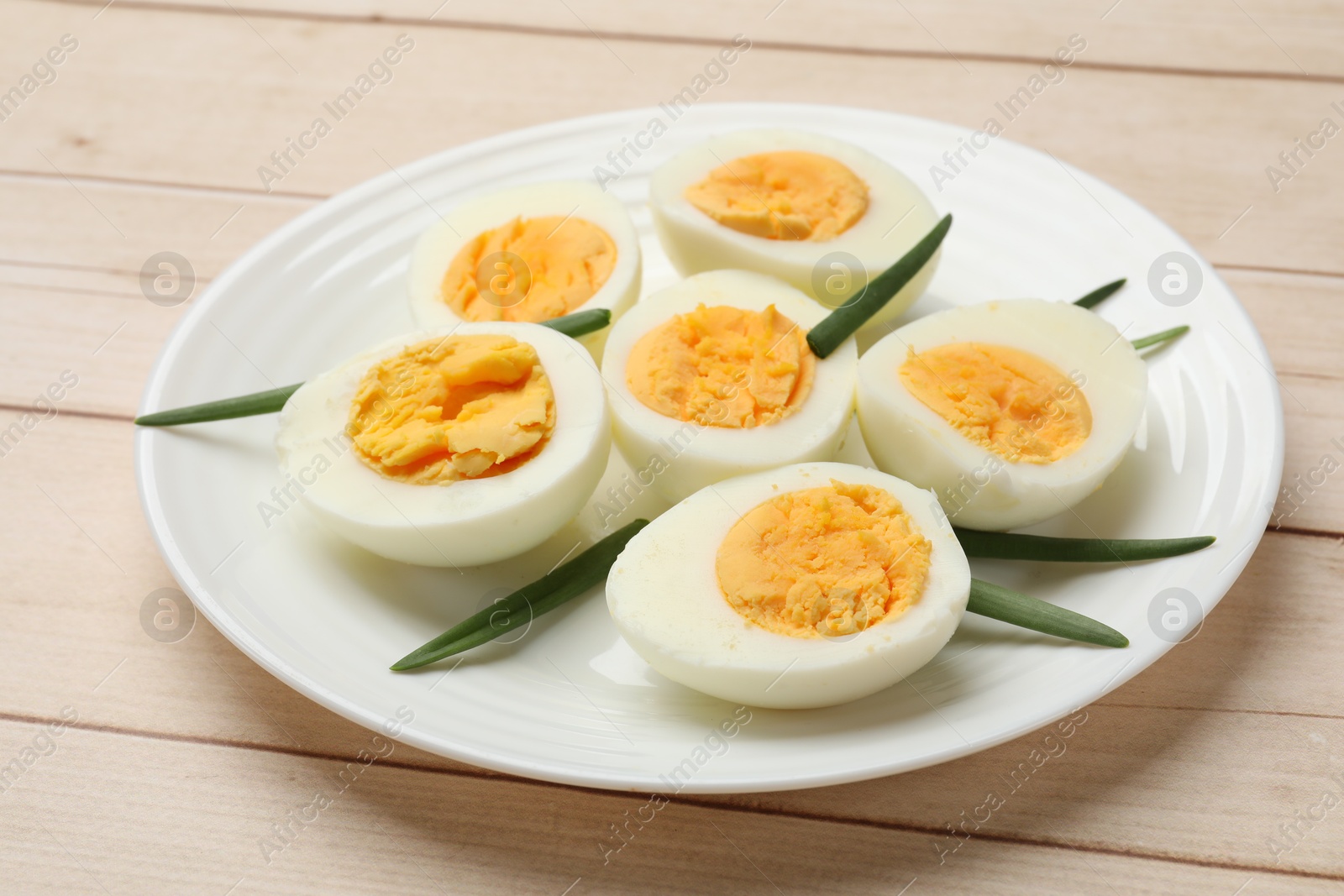 Boiled eggs and green onions on wooden table, closeup Photo of Boiled eggs and green onions on wooden table, closeup