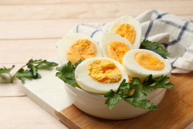 Photo of Boiled eggs and parsley on wooden table, closeup