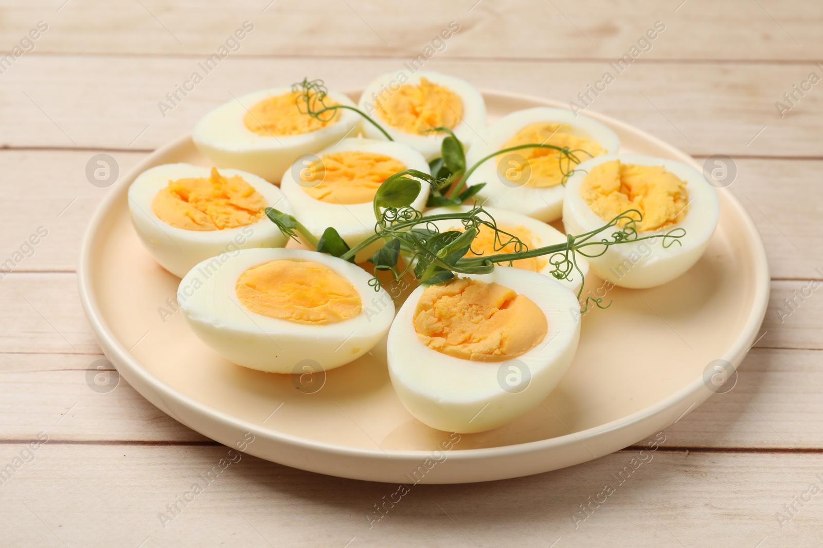 Boiled eggs and microgreens on wooden table, closeup Photo of Boiled eggs and microgreens on wooden table, closeup
