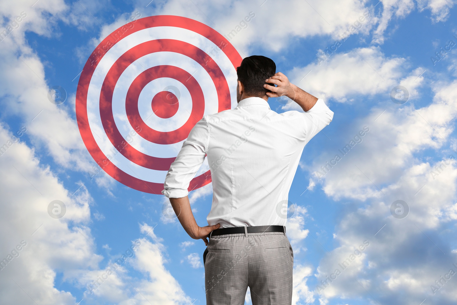 Targeting, goal achievement. Businessman looking at bullseye in sky Image of Targeting, goal achievement. Businessman looking at bullseye in sky