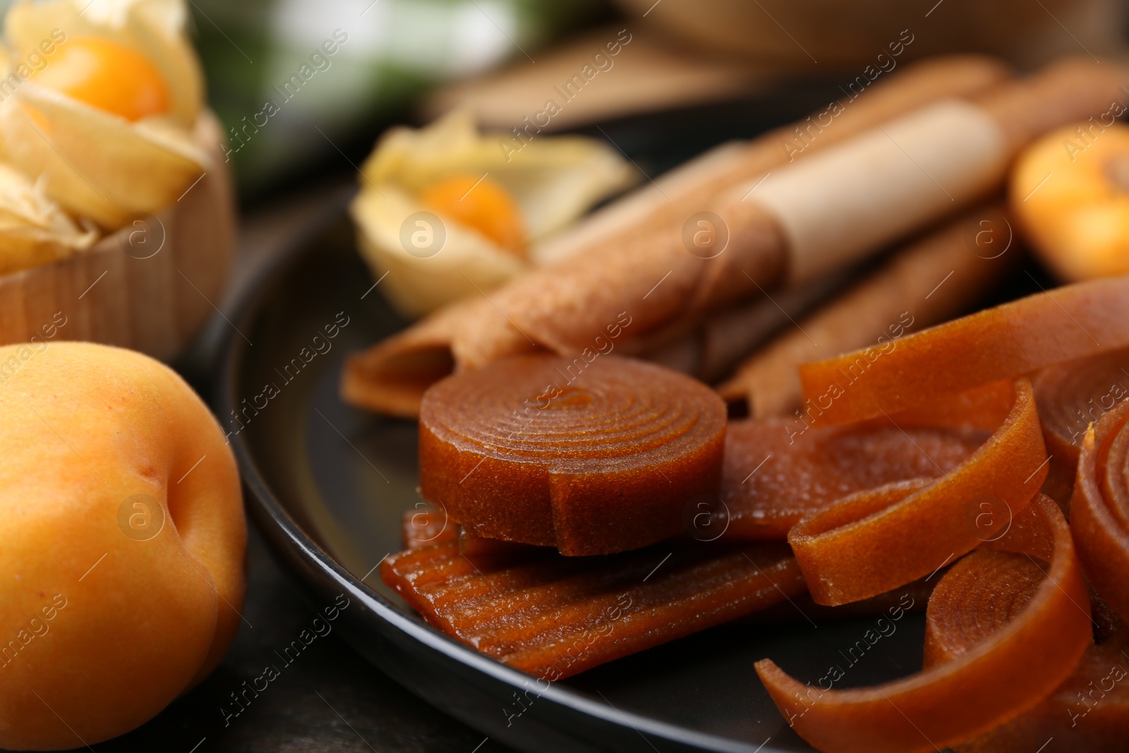 Tasty fruit leather and apricots on wooden table, closeup Photo of Tasty fruit leather and apricots on wooden table, closeup