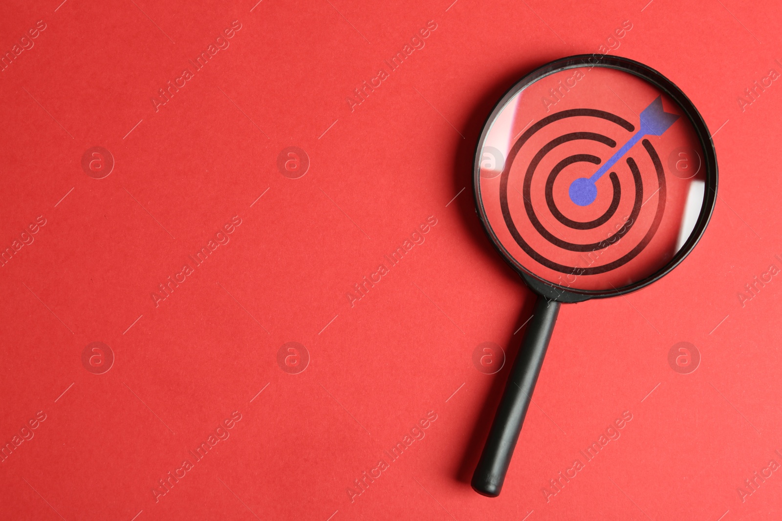 Targeting. Magnifying glass with bullseye inside on red background, top view. Space for text Image of Targeting. Magnifying glass with bullseye inside on red background, top view. Space for text
