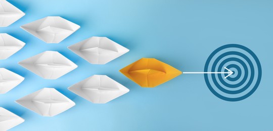 Image of Targeting. Orange paper boat leading white ones to bullseye on light blue background, top view