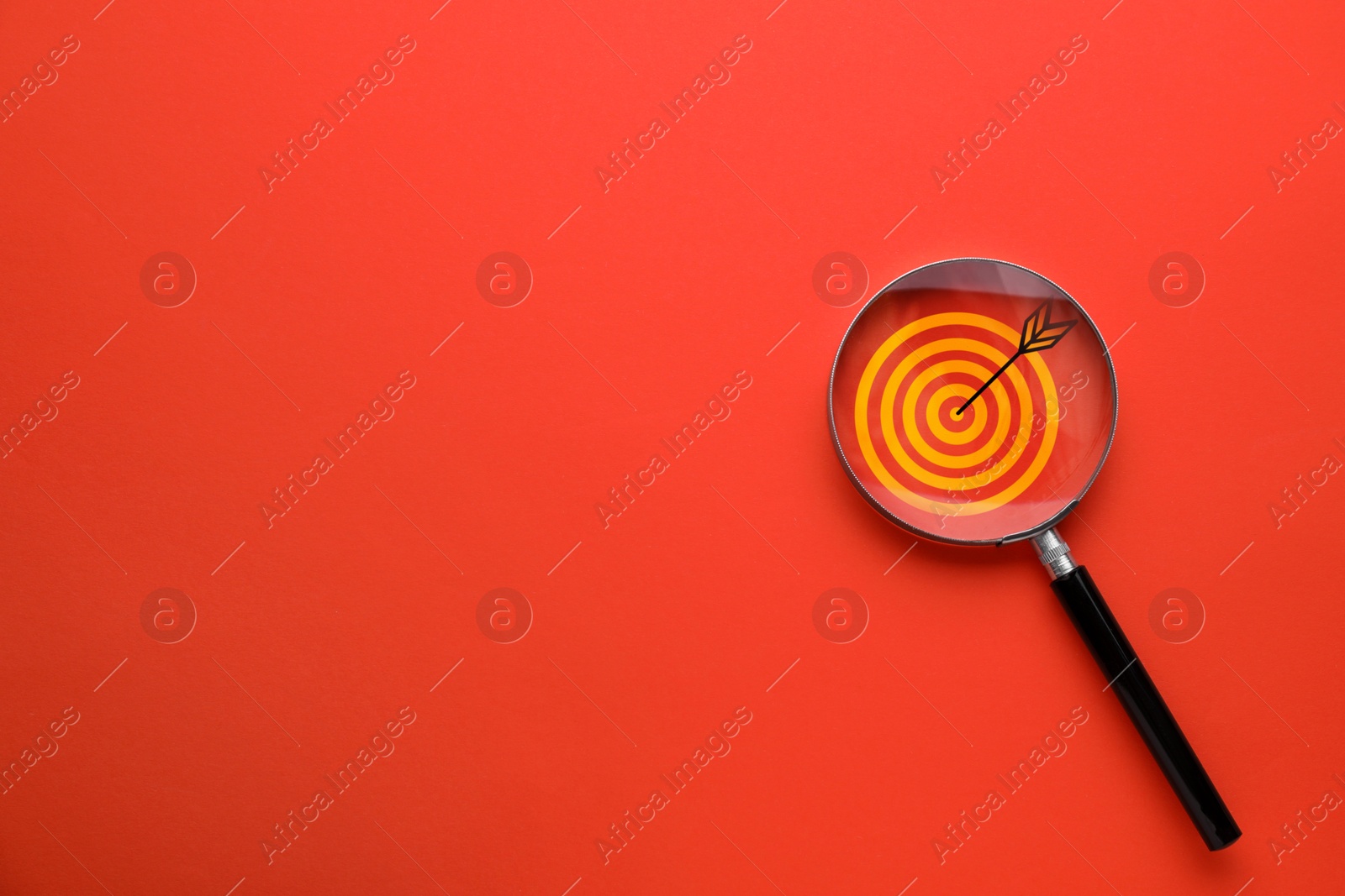 Targeting. Magnifying glass with bullseye inside on red background, top view. Space for text Image of Targeting. Magnifying glass with bullseye inside on red background, top view. Space for text