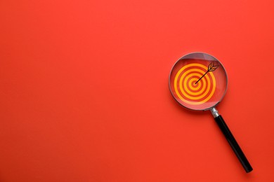 Image of Targeting. Magnifying glass with bullseye inside on red background, top view. Space for text