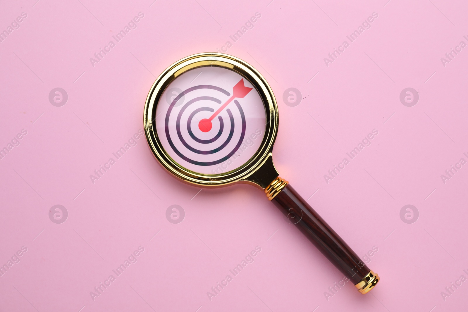 Targeting. Magnifying glass with bullseye inside on pink background, top view Image of Targeting. Magnifying glass with bullseye inside on pink background, top view