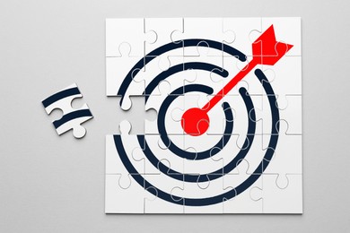 Image of Targeting. One puzzle piece missing to make image of bullseye on light background, top view