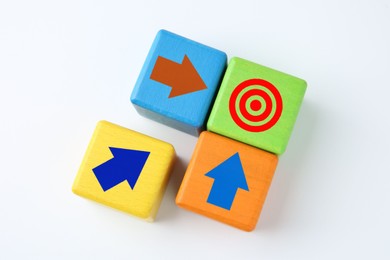 Image of Targeting. Colorful cubes with arrows pointing at green one with bullseye on white background, top view