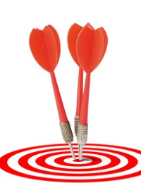 Image of Targeting. Three darts in center of bullseye on white background