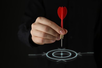 Image of Targeting. Woman aiming at center of virtual bullseye with dart on black background, closeup