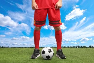 Image of Football player with soccer ball under blue sky, closeup
