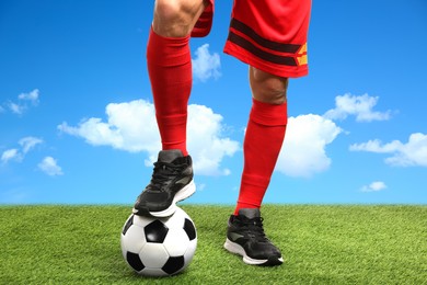 Image of Football player with soccer ball under blue sky, closeup