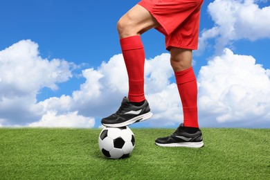 Image of Football player with soccer ball under blue sky, closeup