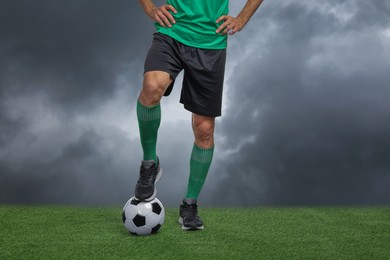 Image of Football player with soccer ball under gloomy sky, closeup