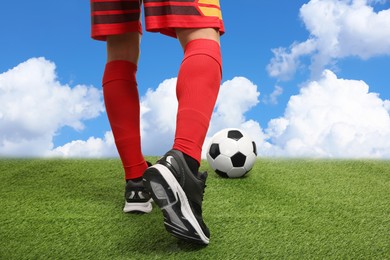 Image of Football player kicking soccer ball under blue sky, closeup