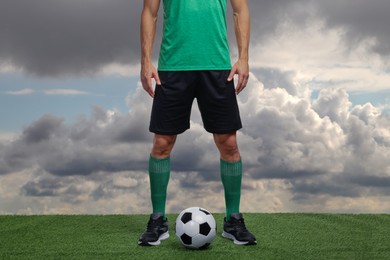 Image of Football player with soccer ball against cloudy sky, closeup