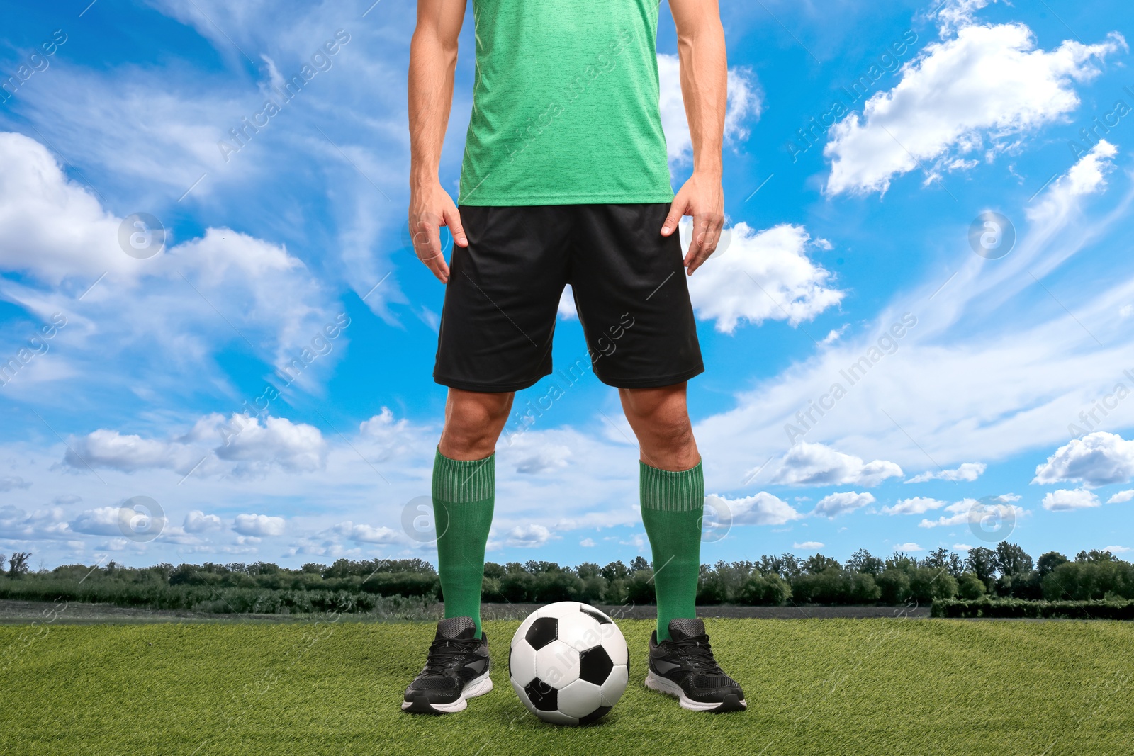 Football player with soccer ball under blue sky, closeup Image of Football player with soccer ball under blue sky, closeup