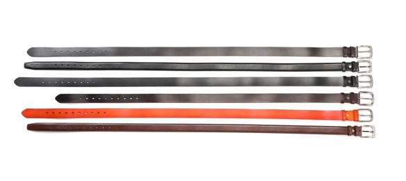 Photo of Different leather belts isolated on white, top view