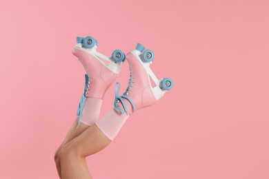 Photo of Woman in roller skates on pink background, closeup. Space for text