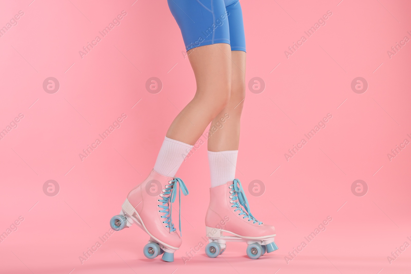 Woman in roller skates on pink background, closeup Photo of Woman in roller skates on pink background, closeup