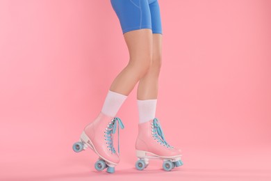 Photo of Woman in roller skates on pink background, closeup