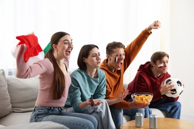 Photo of Emotional football fans watching game together indoors