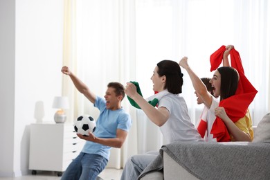 Photo of Emotional football fans watching game together indoors