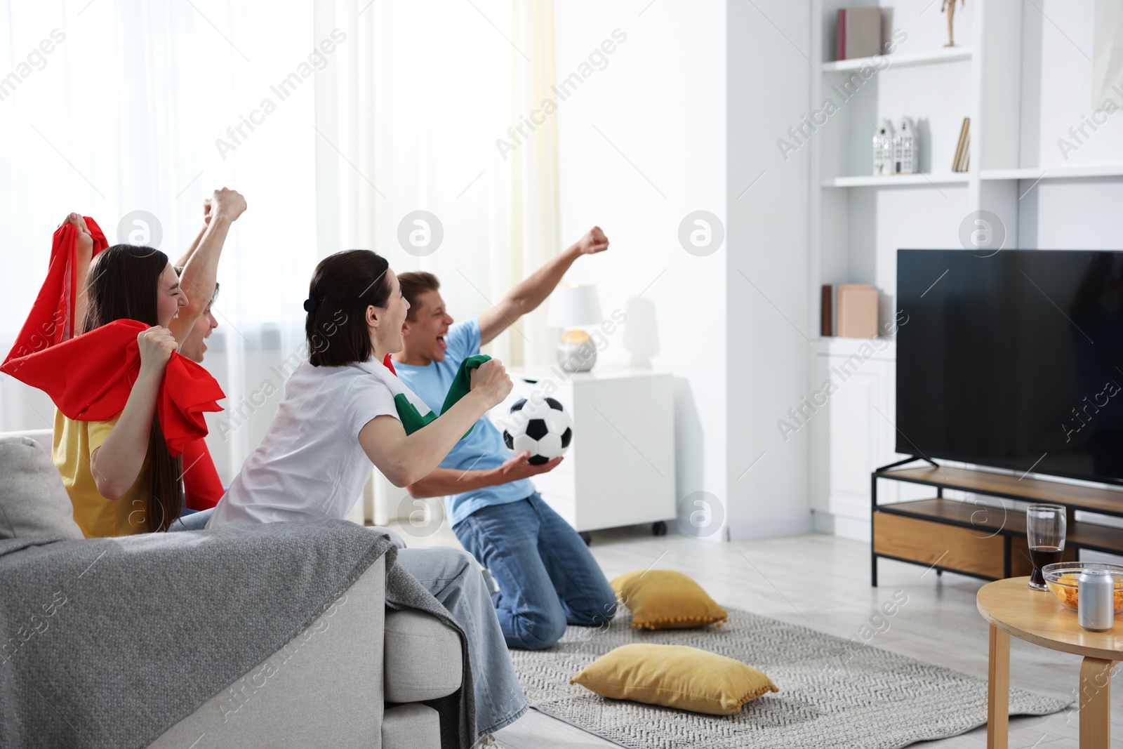Emotional football fans watching game together indoors Photo of Emotional football fans watching game together indoors
