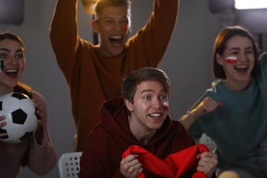 Photo of Emotional sports fans watching game together indoors, selective focus