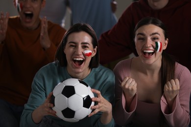 Photo of Emotional sports fans watching game together indoors, selective focus