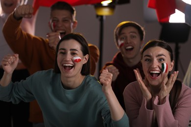 Photo of Emotional sports fans watching game together indoors, selective focus