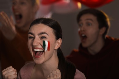 Photo of Emotional sports fans watching game together indoors, selective focus