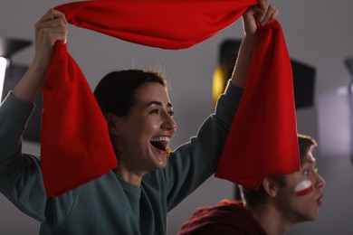 Photo of Emotional sports fans watching game together indoors