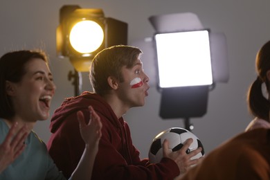 Photo of Emotional football fans watching game together indoors