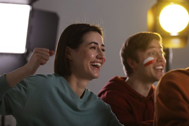 Photo of Emotional sports fans watching game together indoors