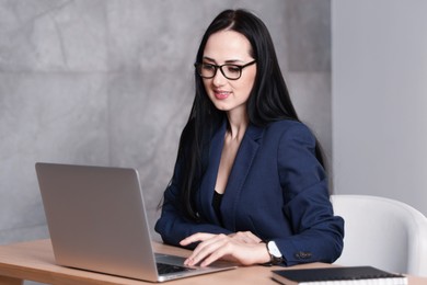 Photo of Professional psychologist working with laptop at table in office