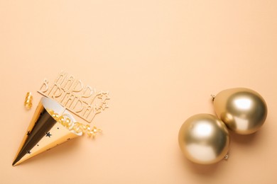 Photo of Party hat, topper, streamers and balloons on beige background, flat lay. Space for text