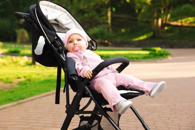 Photo of Cute little baby in stroller at park. Space for text