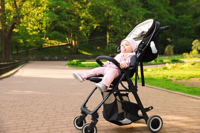 Photo of Cute little baby in stroller at park. Space for text