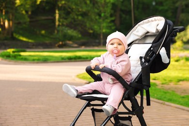 Photo of Cute little baby in stroller at park. Space for text