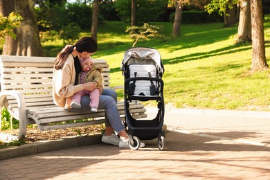 Photo of Mother with her cute baby on bench in park