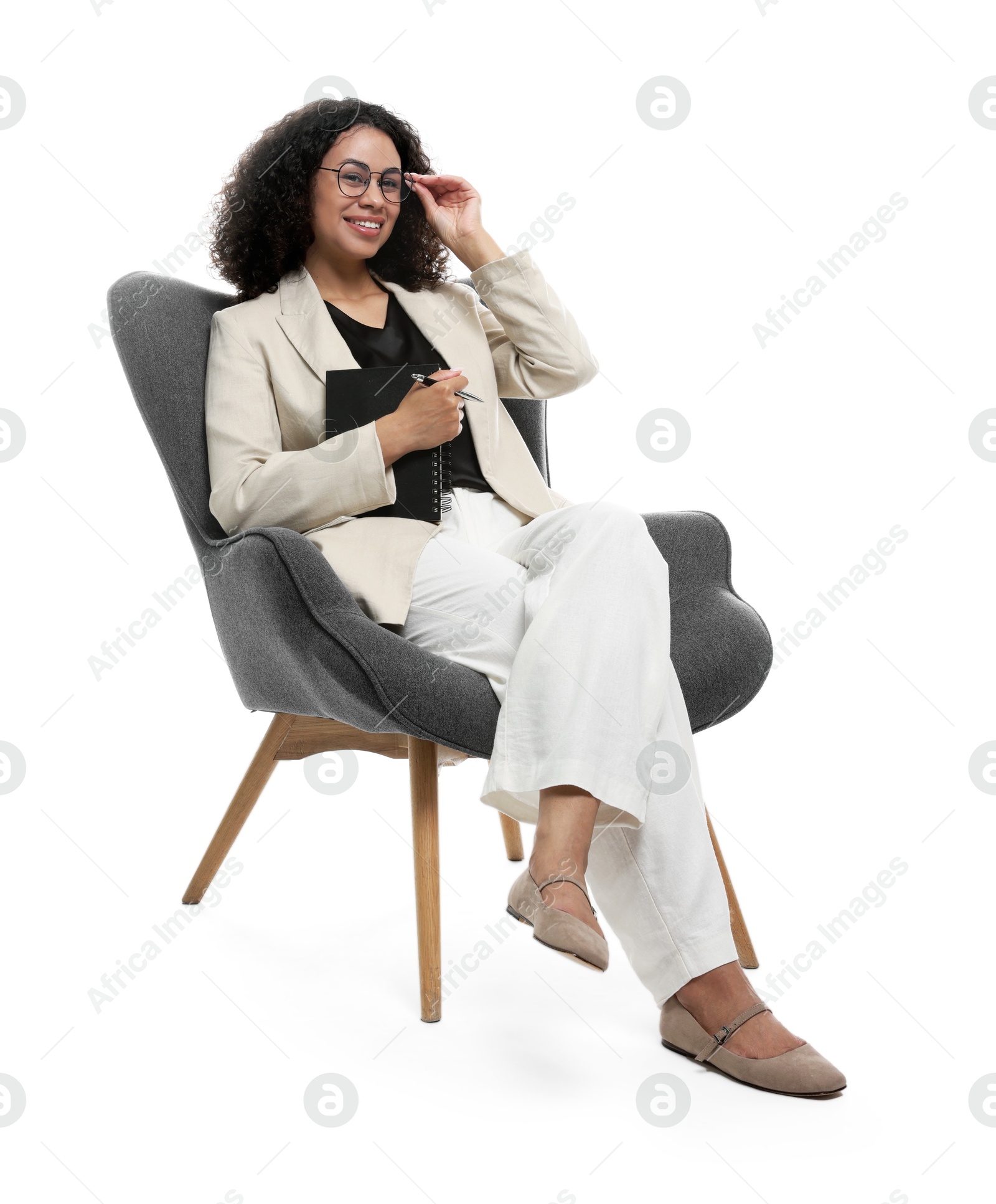 Professional psychologist with notebook and pen in armchair on white background Photo of Professional psychologist with notebook and pen in armchair on white background
