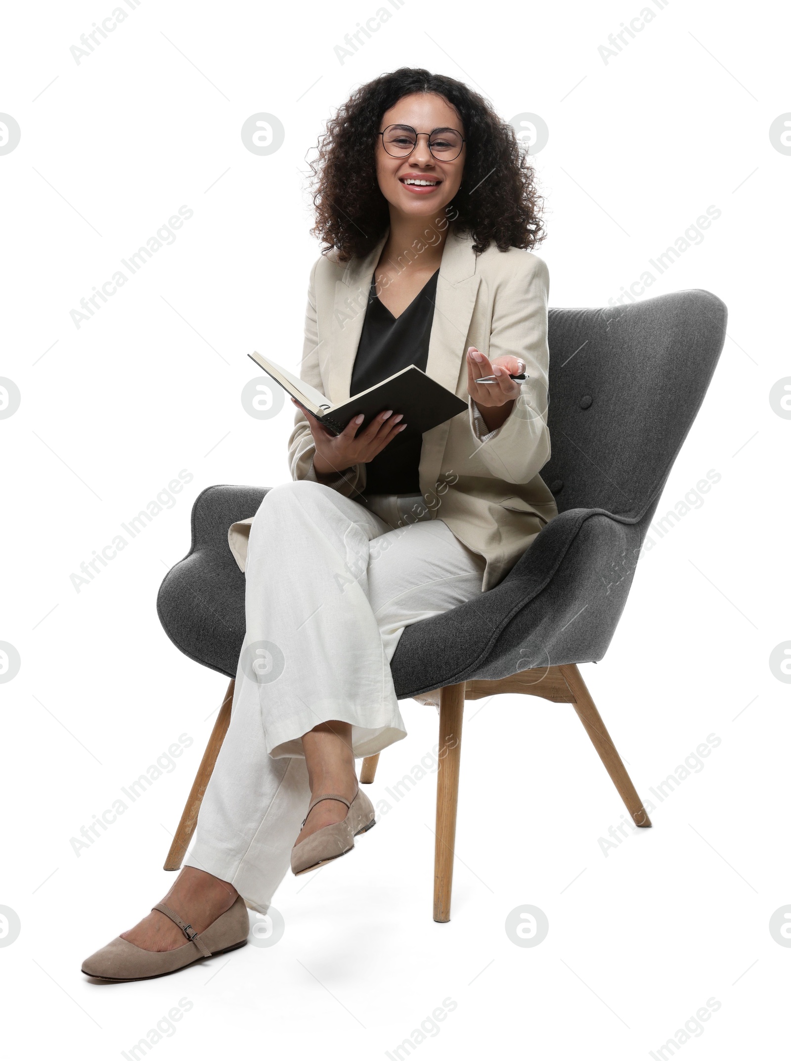 Professional psychologist with notebook and pen in armchair on white background Photo of Professional psychologist with notebook and pen in armchair on white background