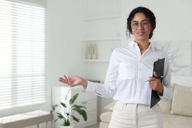 Photo of Professional psychologist with clipboard and pen in office