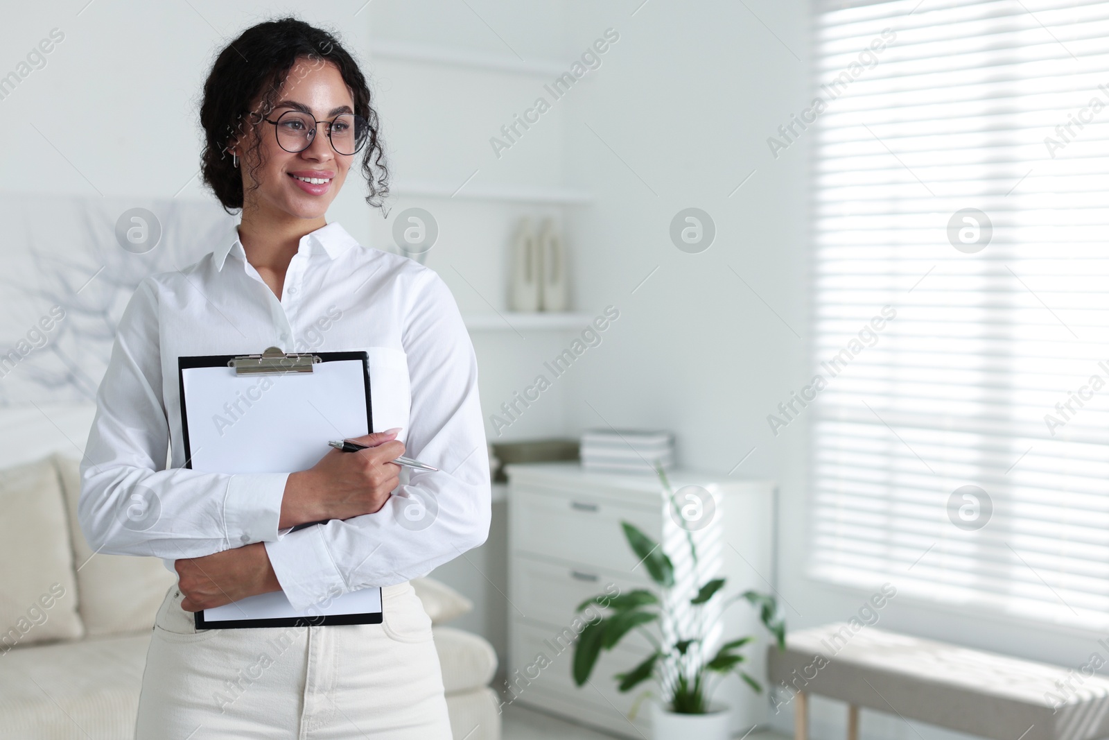 Professional psychologist with clipboard and pen in office, space for text Photo of Professional psychologist with clipboard and pen in office, space for text